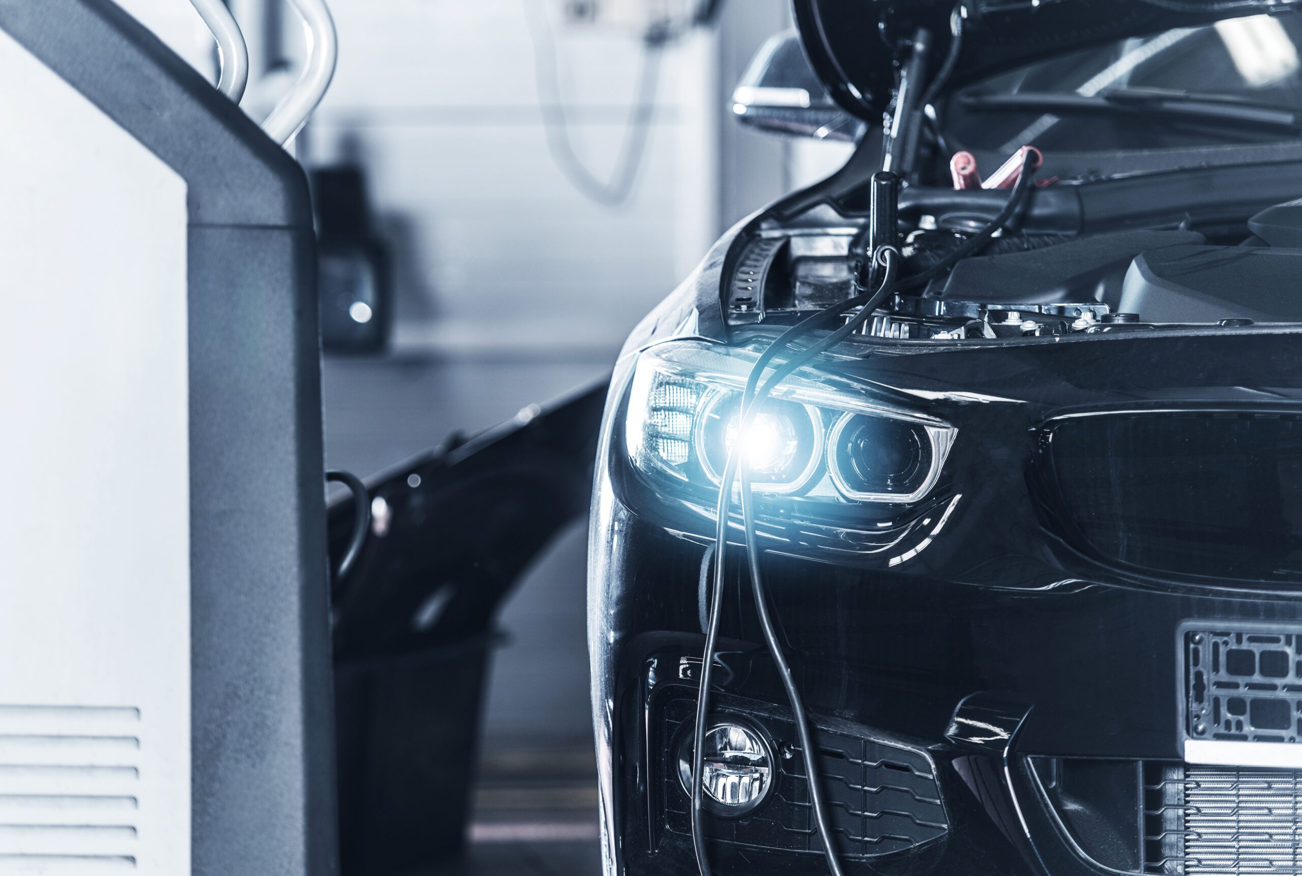 Charging Dead Car Battery Inside Dealership Service Center Closeup Photo. Modern Vehicle Electric Systems. Automotive Industry.